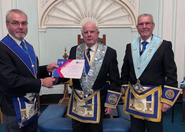 Three members of Merchants' Lodge in regalia at a certificate presentation